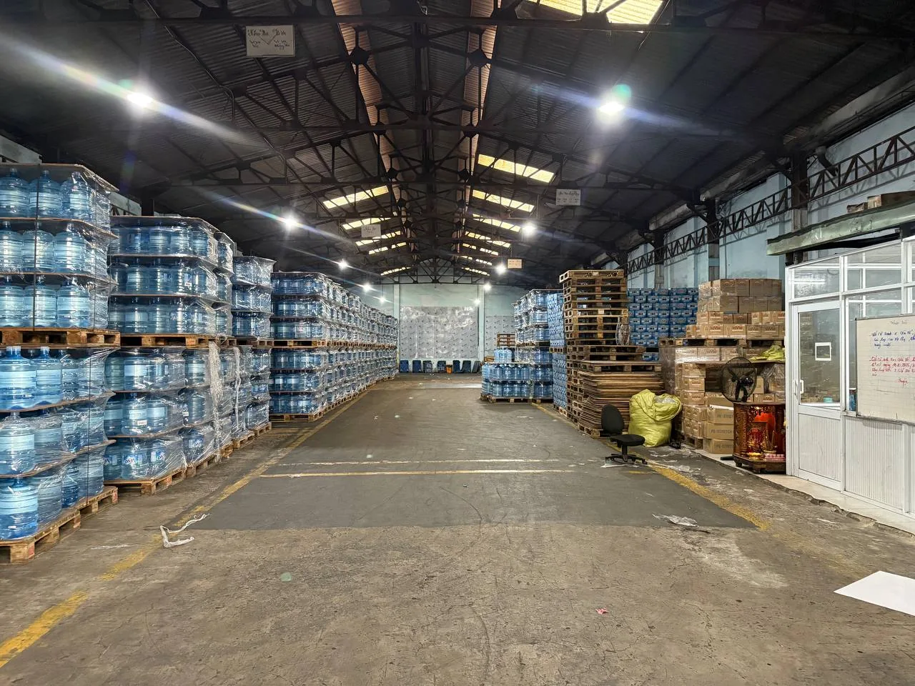Lối đi trong kho Long Giang với các pallet nước xếp ngay ngắn theo hàng